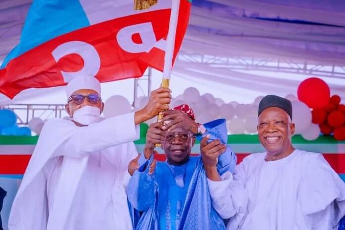President Muhammadu Buhari (L), supported by the National Chairman of the All Progressives Congress (APC), Senator Abdullahi Adamu (R), presenting the party's flag to the winner of the last presidential primaries, Asiwaju Bola Ahmed Tinubu (M), ahead of the 2023 general elections.
