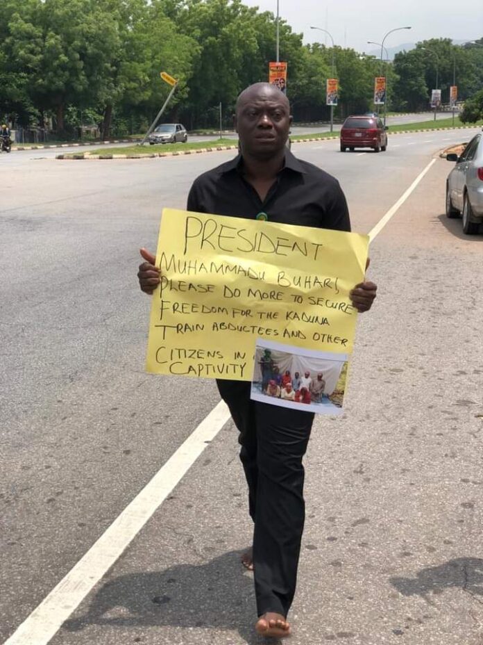 One of the protesters, protesting Barefoot with banner saying, the president should secure freedom for the Kaduna Train abductees.