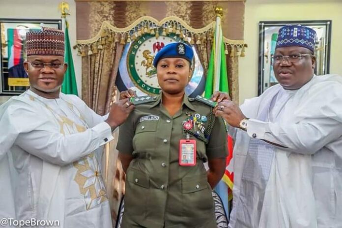 Governor Yahaya Bello of Kogi state (L) and Senate President, Ahmad Lawan (R) decorating the former's ADC, Iwanger Ifeoma Akaya (M), on her promotion from the rank of Assistant Superintendent of Police (ASP) to Deputy Superintendent of Police (DSP).