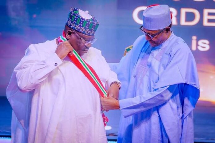Photo caption: Buhari (right) decorating Senate President, Ahmed Lawan, at the event
