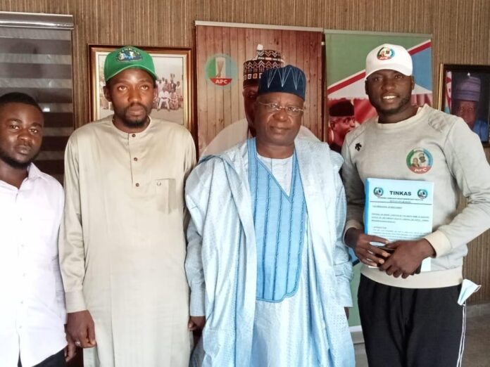 Mohammed Waziri (R), the trekker, being received by APC officials in Abuja.