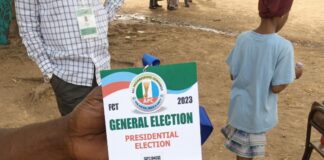 Aliyu, one of the APC agents at the Utako Primary School polling unit, displaying his identification tag
