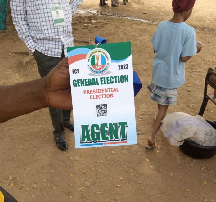 Aliyu, one of the APC agents at the Utako Primary School polling unit, displaying his identification tag