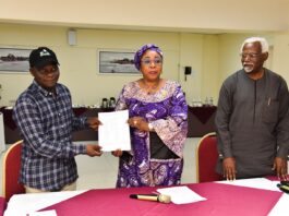 Head of the Civil Service of the Federation, Mrs Didi Esther Walson-Jack, OON,mni( middle), presenting a copy of the signed Memoranda of Understanding(MOU) on Consequential Adjustments in Salaries to the National Chairman,JNPSNC Comrade Benjamin Anthony(L), while the Chairman, National Salaries, Incomes and Wages Commission, Mr Ekpo Nta(R), looks on.