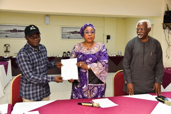 Head of the Civil Service of the Federation, Mrs Didi Esther Walson-Jack, OON,mni( middle), presenting a copy of the signed Memoranda of Understanding(MOU) on Consequential Adjustments in Salaries to the National Chairman,JNPSNC Comrade Benjamin Anthony(L), while the Chairman, National Salaries, Incomes and Wages Commission, Mr Ekpo Nta(R), looks on.