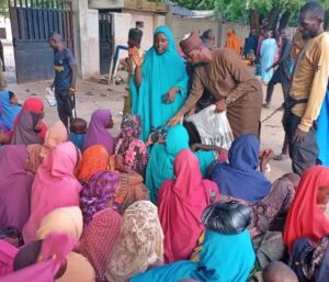 Distributing food to flood victims at the State Mechanical Workshop in Maiduguri.